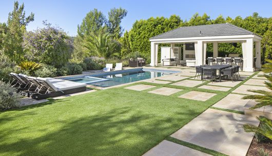 fake grass installation facing backyard with pool